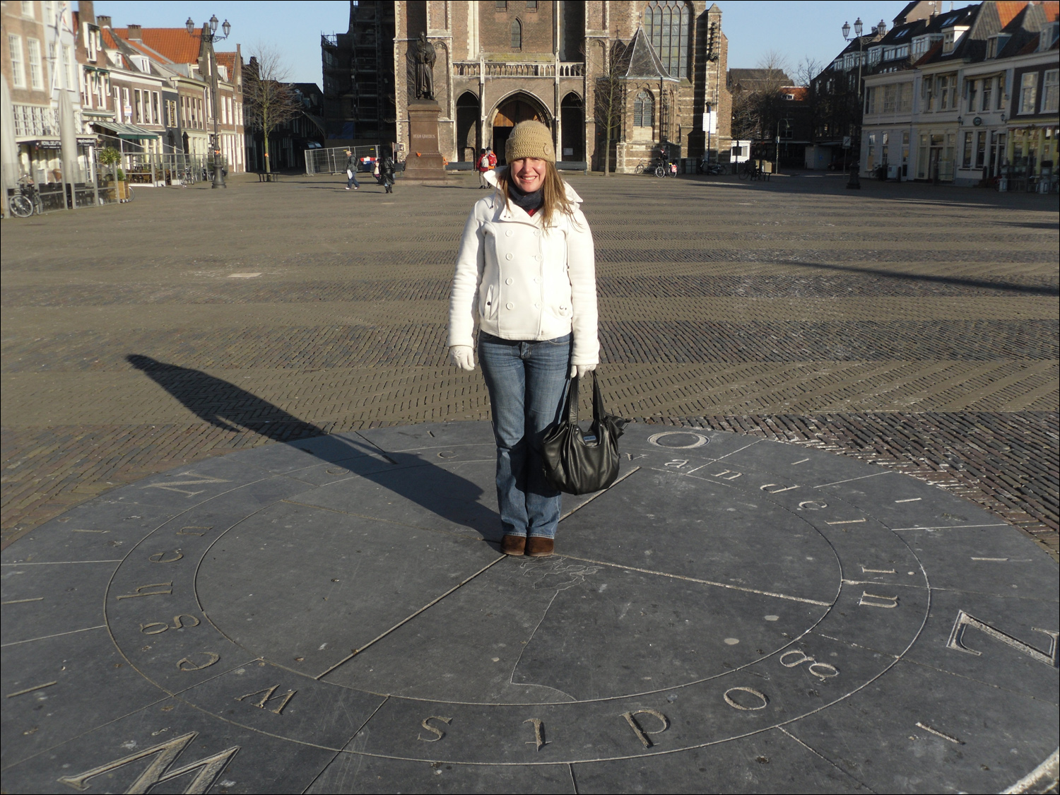 Becky standing on a compass in the Delft Square